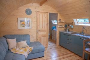 a living room with a blue couch in a kitchen at Glamping Dragonja River in Šmarje
