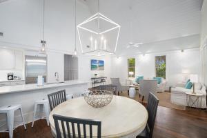 Camp District of WaterColor - Outdoor TV and Porches في شاطئ سانتا روزا: مطبخ وغرفة معيشة مع طاولة وكراسي