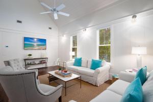 Camp District of WaterColor - Outdoor TV and Porches في شاطئ سانتا روزا: غرفة معيشة بأثاث أبيض وموقد