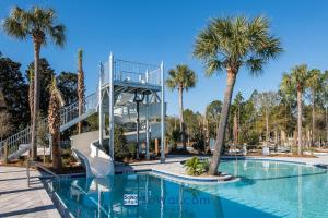 Camp District of WaterColor - Outdoor TV and Porches في شاطئ سانتا روزا: منتجع مع حمام سباحة وأشجار النخيل