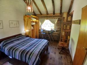 ein Schlafzimmer mit einem Bett und einem Tisch in einem Zimmer in der Unterkunft Posada Boutique- Casa de Campo Arroyo Huirihuiri in Aluminé + 25 Fotos