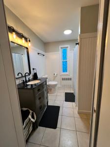 a bathroom with a sink and a toilet and a mirror at Holyoke House Oasis - Calm Trips in Holyoke +23 photos