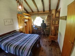 Ein Mann, der an einem Tisch in einem Zimmer sitzt. in der Unterkunft Posada Boutique- Casa de Campo Arroyo Huirihuiri in Aluminé