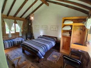 ein Schlafzimmer mit einem Bett und einem Schreibtisch in einem Zimmer in der Unterkunft Posada Boutique- Casa de Campo Arroyo Huirihuiri in Aluminé