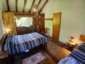 Zimmer mit 2 Betten und einem Fenster in einer Hütte in der Unterkunft Posada Boutique- Casa de Campo Arroyo Huirihuiri in Aluminé