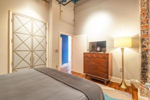 a bedroom with a bed and a dresser and a television at 80 Lex 203 Eclectic Industrial Apt in Asheville