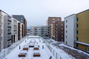 a courtyard in a city with snow covered buildings at Easy Stay Rooms & Apartments near Airport in Vantaa