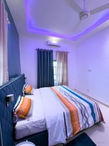 a bedroom with a bed with a colorful blanket on it at Adole Guest House in Abomey-Calavi