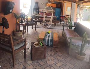 a living room with a couch and chairs and a table at Trem de Pouso Rustic Guest House in Tiradentes