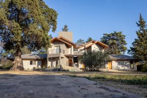a house with a tree in front of it at Samai Suma Cabañas & Spa in Villa General Belgrano