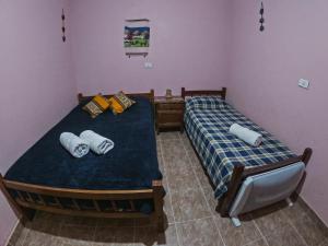 a bedroom with two twin beds and a tv at Imaynalla Humahuaca Hostl in Humahuaca