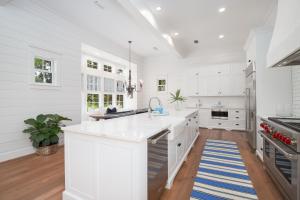 una cocina con armarios blancos y una alfombra azul y blanca en Private Pool - Carriage House - Ping Pong - Luxury, en Santa Rosa Beach