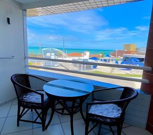 a balcony with a table and chairs and a view of the ocean at MoviHosts Terrazzo in Natal