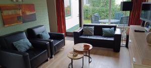 een woonkamer met twee banken en een tafel bij vakantiebungalow in Simpelveld +9 foto's