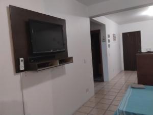 a living room with a flat screen tv on a wall at Torres a mais bela praia gaúcha in Torres