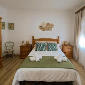 Un dormitorio con una cama grande con almohadas azules y blancas. en La Cantera, en Corbera