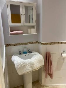 a bathroom with a white sink and a mirror at Lovely centrally located 2 bed flat in Southsea in Portsmouth