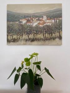 a plant in a vase in front of a painting at Lovely centrally located 2 bed flat in Southsea in Portsmouth