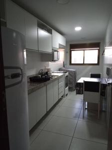 Una cocina con gabinetes blancos y un fregadero. en Apartamento Azul Turquesa Praia do Forte Tudo a Pé, en Cabo Frío
