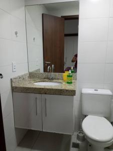 Un baño con un inodoro blanco y un lavabo. en Apartamento Azul Turquesa Praia do Forte Tudo a Pé, en Cabo Frío
