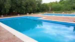 a swimming pool with blue water in a yard at Hostería Villa Luz Habitación 1 in San Marcos Sierras