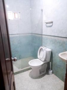 a bathroom with a toilet and a shower and a sink at Hostal Renacer in Cartagena de Indias