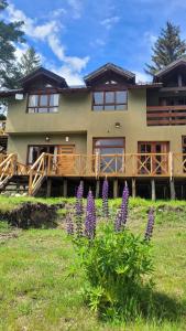a house with purple flowers in front of it at La Margarita in El Bolsón