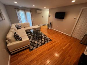 ein Wohnzimmer mit Sofa und Fernseher in der Unterkunft Premium Private Suite with Parking and Workspace in South Windsor