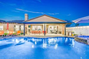 a swimming pool in front of a house at Hollywood Hideaway with 158" Poolside TV and 2 Arcades in Indio