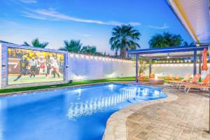 a swimming pool with a mural of a football game at Hollywood Hideaway with 158" Poolside TV and 2 Arcades in Indio