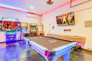 a room with a pool table and arcade games at Hollywood Hideaway with 158" Poolside TV and 2 Arcades in Indio