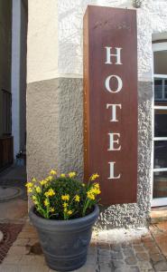 a pot of flowers sitting in front of a sign at Hotel Goldene Steig in Kempten