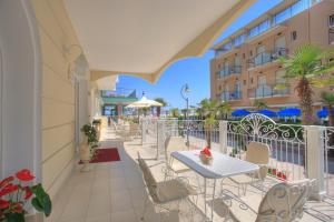 een balkon met een tafel en stoelen en een gebouw bij Hotel Rosa Maria Elite in Bellaria-Igea Marina