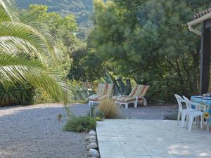 a patio with chairs and tables in a garden at Spacious holiday home by the river in Le Boulou