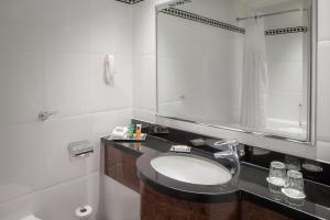 a bathroom with a sink and a mirror at Glasgow Grosvenor Hotel in Glasgow