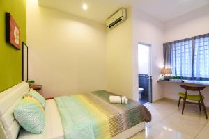 a bedroom with a bed and a desk at Saffron Stay Melaka in Malacca