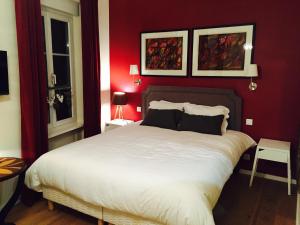 ein Schlafzimmer mit einem großen weißen Bett mit roten Wänden in der Unterkunft Villa Kleber in Straßburg