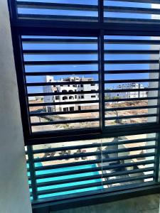 - une vue sur un bâtiment depuis une fenêtre avec des stores dans l'établissement Liliapart, à Agadir
