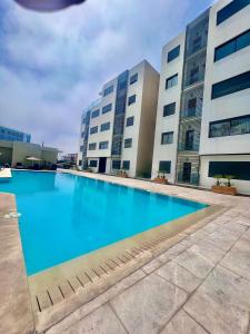 une grande piscine en face de deux bâtiments dans l'établissement Liliapart, à Agadir
