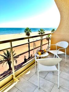 a room with a balcony with a view of the beach at Suite Balnéo Canet in Canet-en-Roussillon