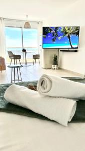 a woman laying on a bed in a living room at Suite Balnéo Canet in Canet-en-Roussillon