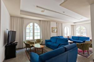 a living room with blue couches and a tv at Hotel Rosa Maria Elite in Bellaria-Igea Marina