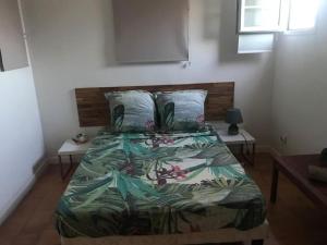 Un dormitorio con una cama con un edredón colorido. en Chambre en appart Duplex chez l'habitant, en Les Trois-Îlets