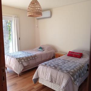 ein Schlafzimmer mit zwei Betten und einem Fenster in der Unterkunft Casa Müller Mendoza in Ciudad Lujan de Cuyo