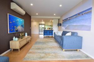 浅滩湾Shoal Vibes的带蓝色沙发的客厅和厨房