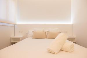 a white bedroom with a large white bed with pillows at Rest Pedrouzo in O Pedrouzo