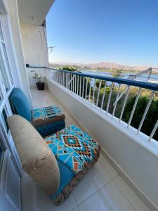 a balcony with a rattan chair and a pillow at luxor Nile view duplex apartment in Luxor