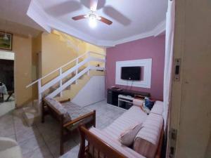 a living room with a couch and a tv at Casa com Piscina na Enseada in Guarujá