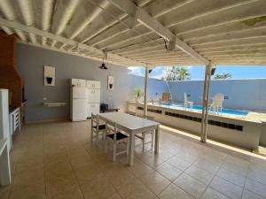 a kitchen with a table and a refrigerator on a patio at Casa com Piscina na Enseada in Guarujá