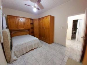 a bedroom with a bed and wooden cabinets at Casa com Piscina na Enseada in Guarujá
